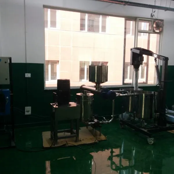 Peanut butter processing setup with feed hopper, grinding unit and mixing vessels