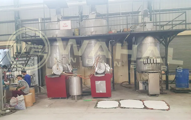 Wahal S.C. formulation plant with tanks on a mezzanine, bead mills below and workers on the factory floor