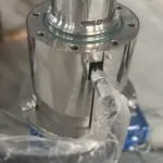 Stainless steel bottom-mounted homogenizer head with a slotted stator, partly wrapped in protective film