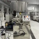 Horizontal bead mill with control panel and cooling unit installed in a production facility
