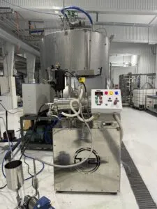 Horizontal bead mill with control panel and cooling unit installed in a production facility