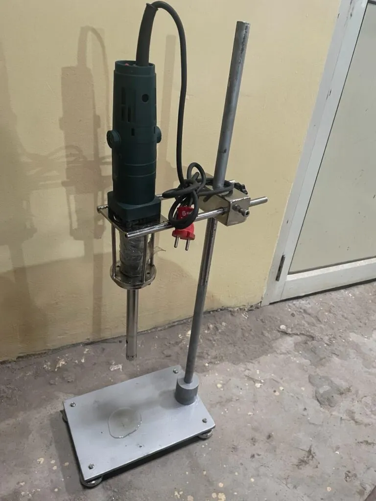 Handheld tissue homogenizer with rotor-stator probe clamped to a laboratory stand