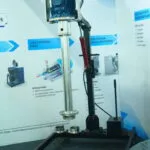 Wahal enclosed-shaft IBC tank mixer on a hydraulic lifting stand at an exhibition booth